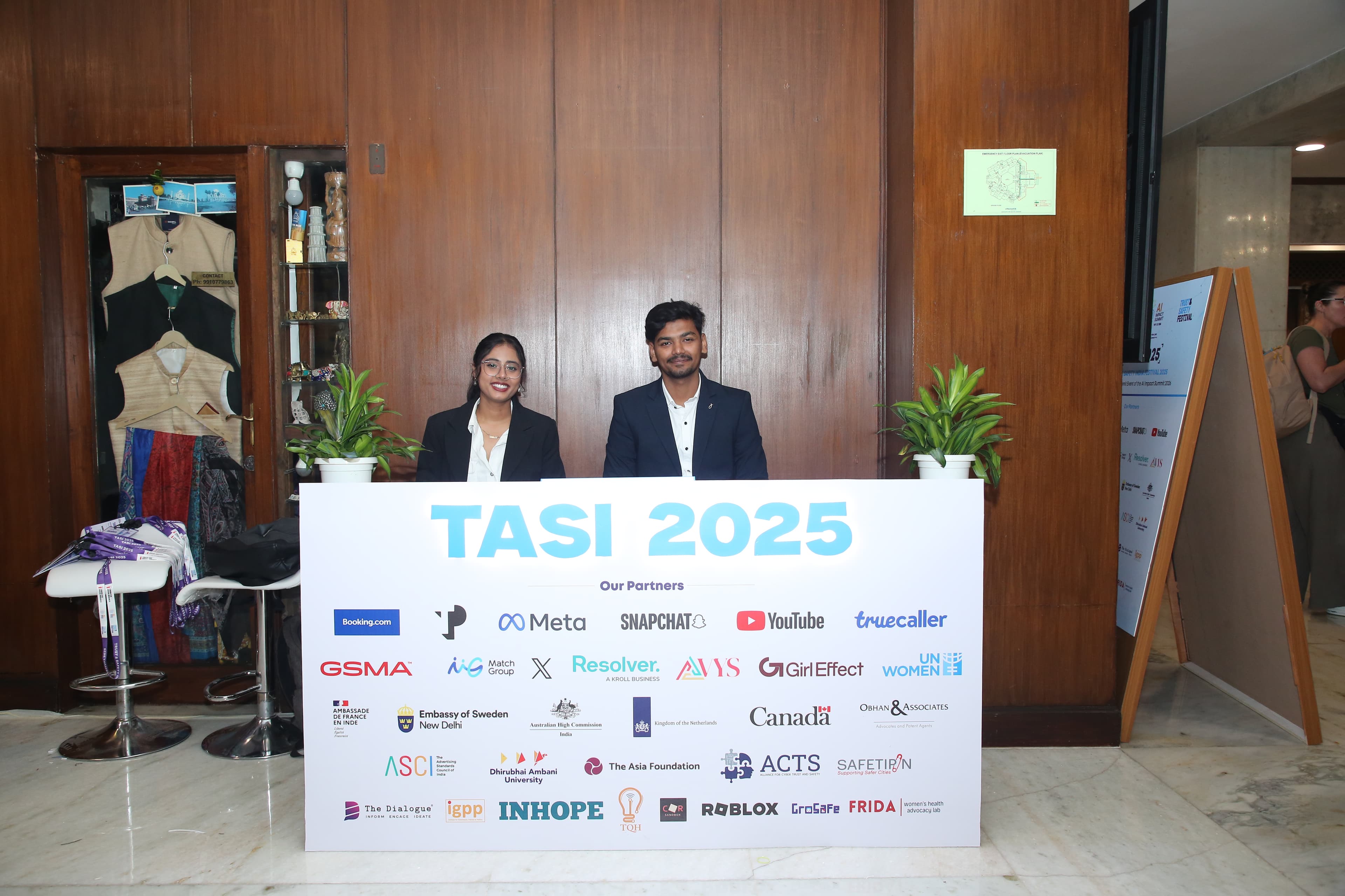 Volunteer team members standing behind a TASI partner display